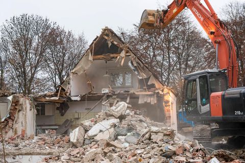Ein Bagger reißt ein Wohnhaus in Bayer ab