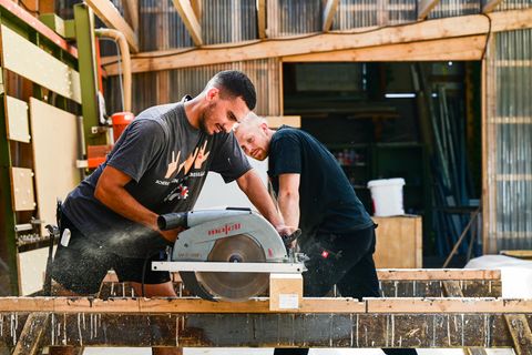 Shariar Nikbakht sägt Holz mit Moritz Wierzba