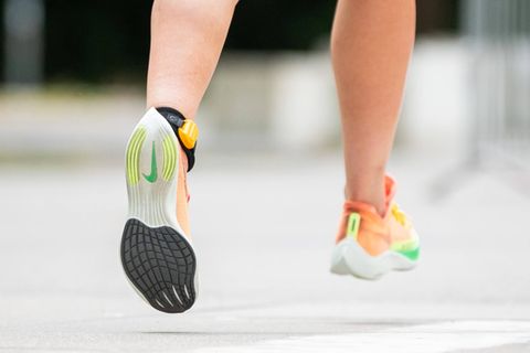 Eine Sportlerin läuft bei einem Triathlon auf der Laufstrecke mit Laufschuhen von Nike