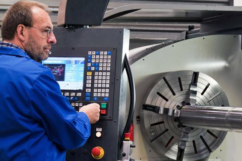 Ein älterer Arbeitnehmer bedient eine CNC-Fräsmaschine