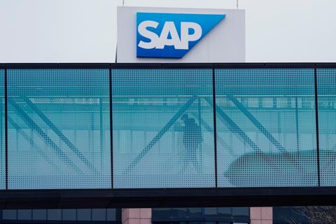 Ein Mann geht über eine verglaste Brücke zwischen zwei Firmengebäuden des Softwarekonzerns SAP.