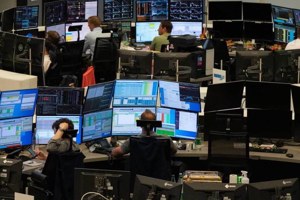 Aktienhändler sitzen vor ihren Monitoren im Handelssaal der Deutschen Börse