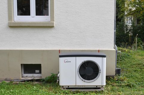 Eine Wärmepumpe steht vor einem Haus