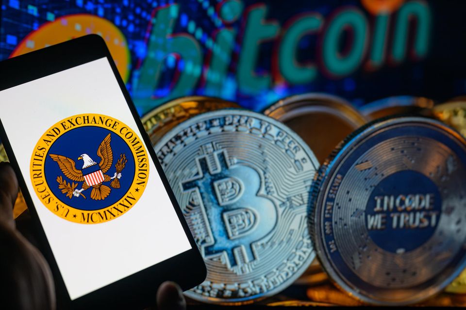 Das Logo der US-Börsenaufsicht SEC vor Bitcoin-Münzen