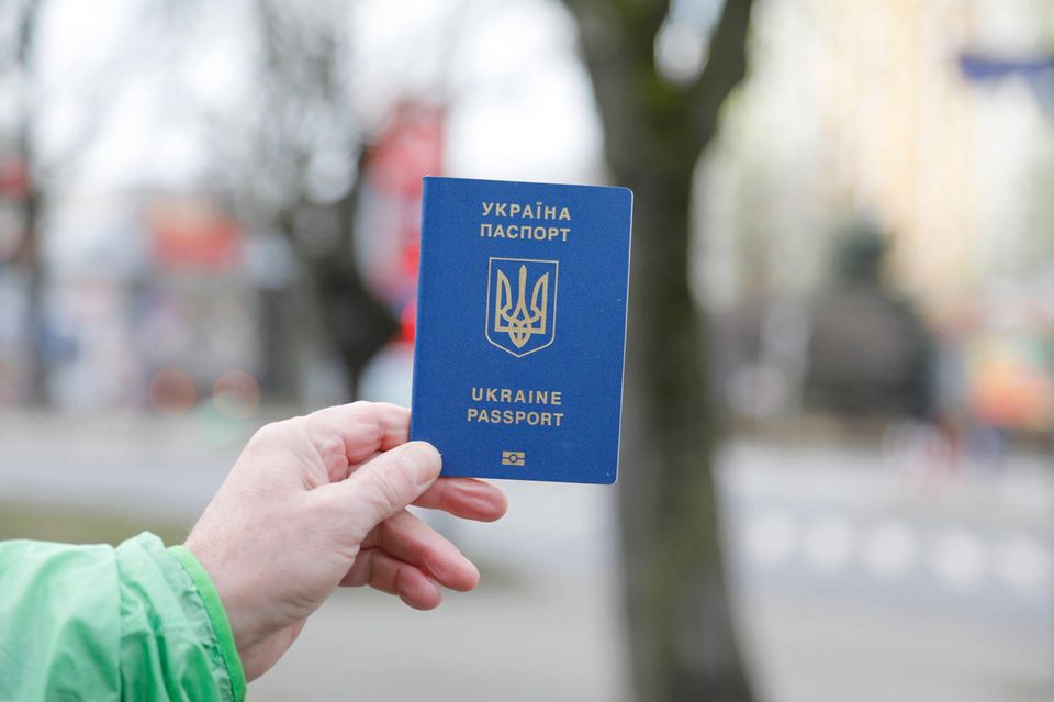 Ein Mann zeigt bei der Einreise nach Deutschland einen ukrainischen Reisepass vor