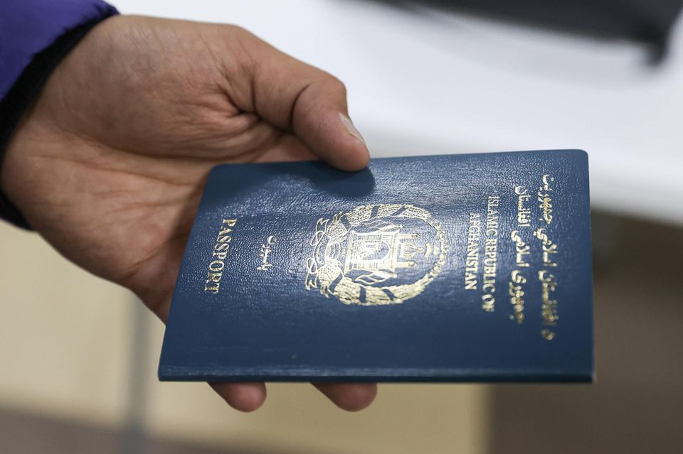 Ein Reisender zeigt seinen afghanischen Reisepass vor