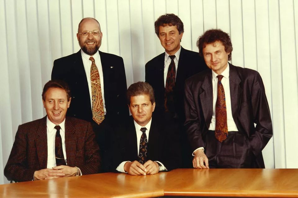 1979: Hasso Plattner (4. v. l.) übernimmt die Gesamtverantwortung für den Bereich Technologie. Die erste Software für Finanzbuchhaltung heißt „RF“ und bildet den Grundstein für ein modulares System, das später als „SAP R/1“ weltbekannt wird. Schon in den ersten Jahren entscheiden sich große Unternehmen für Plattners Produkt: darunter Burda, Schulze-Pharma, Hugo Mann, Reemtsma, Roth-Händle und Linde. 1981 erscheint die zweite Software-Version „R/2“. Beim zehnjährigen Firmenjubiläum können Plattner und seine Mitstreiter 250 Kunden, 24 Mio. DM Umsatz und 100 Mitarbeiter feiern. Auf dem Foto zu sehen ist der SAP-Vorstand von 1991 (von links): Hans-Werner Hector, Klaus Tschira, Dietmar Hopp, Hasso Plattner und Henning Kagermann.