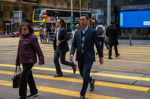 Menschen in Hongkong überqueren eine Straße
