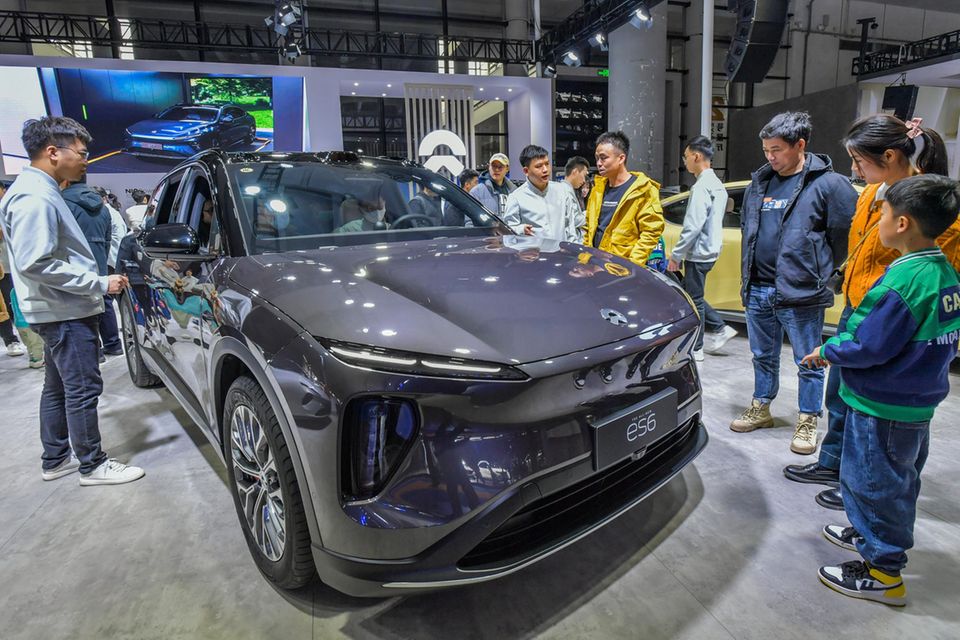 Besucher schauen sich ein Nio-Auto bei einer Ausstellung an