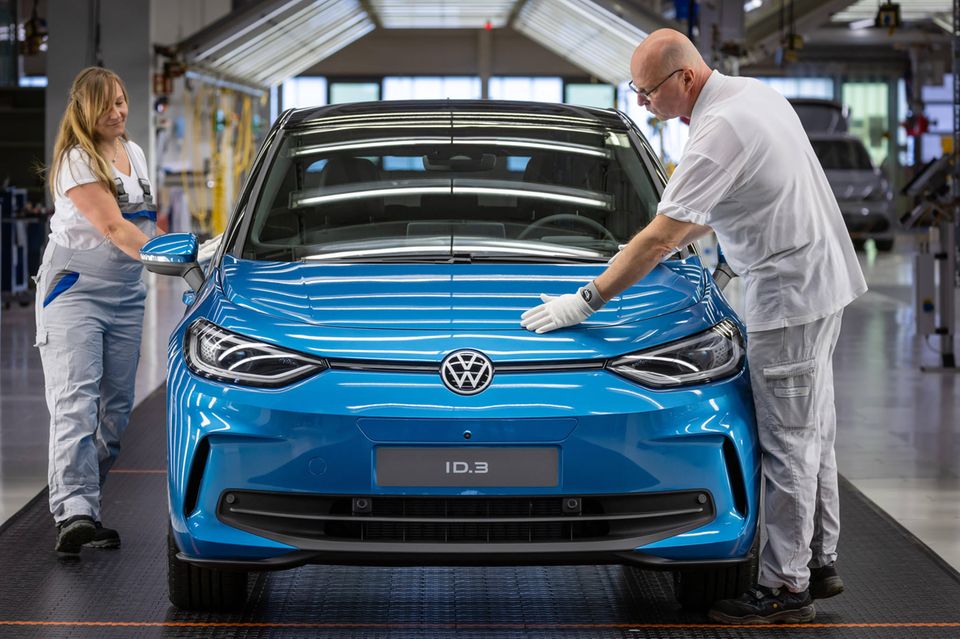 VW-Mitarbeiter bei der Qualitätskontrolle in einem Lichttunnel