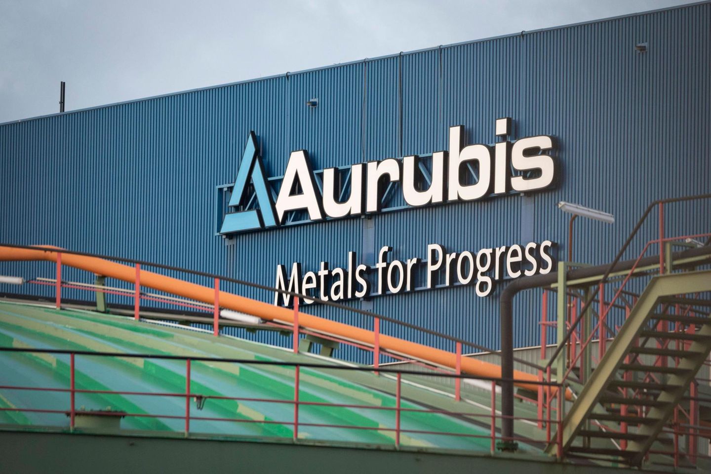 Logo und Schriftzug Aurubis Metal for Progress an einer Fabrikhalle im Werk der Aurubis AG