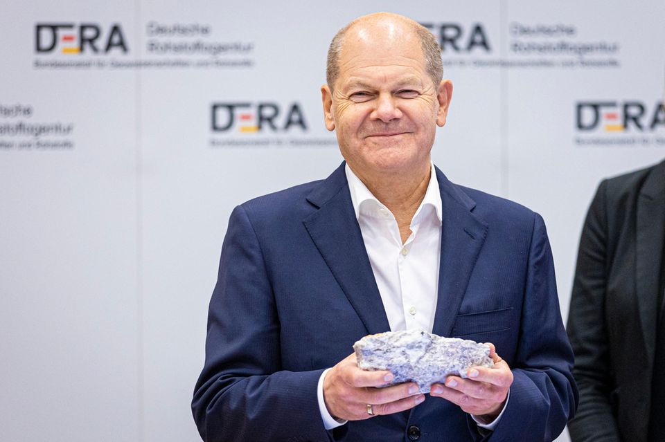 Olaf Scholz hält Lithiumerz in den Händen