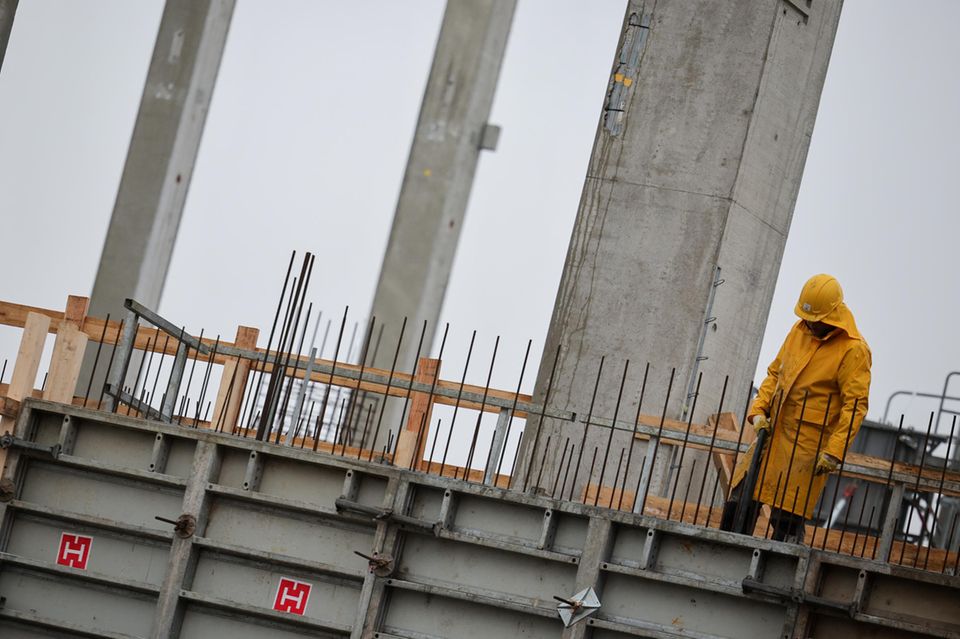 Arbeiter bei Betonarbeiten auf einer Baustelle für ein Industriegebäude