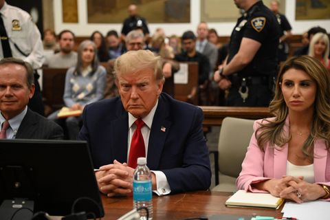 Donald Trump mit grimmiger Mine sitzt mit seinen Anwälten im Gerichtssaal