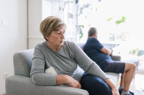 Ein getrenntes Ehepaar sitzt weit auseinander auf dem Sofa