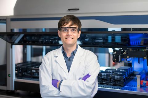 Sanofi-Forscher Norbert Furtmann mit Kittel und Schutzbrille