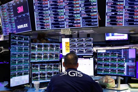 Ein Aktienhändler sitzt vor seinen Bildschirmen an der New Yorker Börse