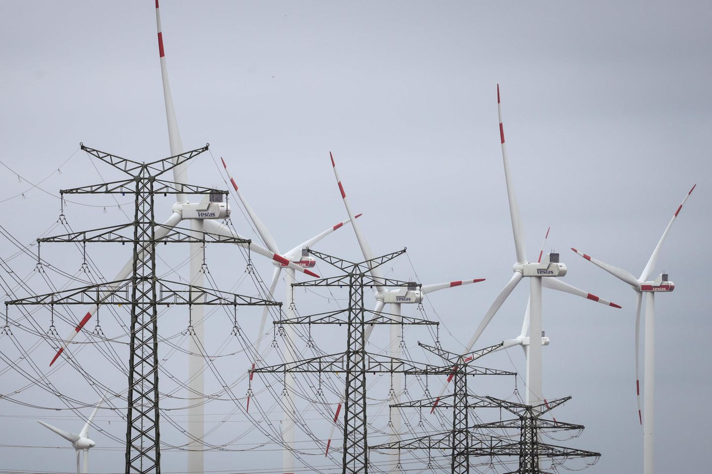 Windräder sind hinter Strommasten am Umspannwerk Heide West zu sehen