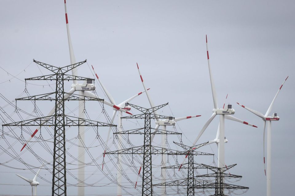 Windräder sind hinter Strommasten am Umspannwerk Heide West zu sehen