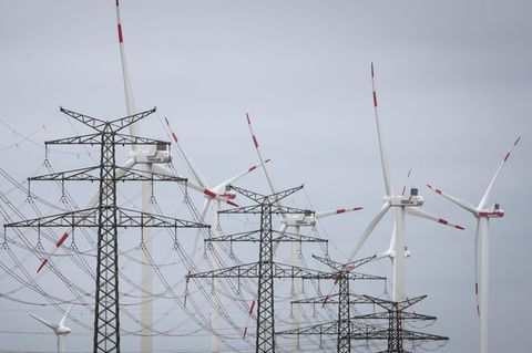 Windräder sind hinter Strommasten am Umspannwerk Heide West zu sehen