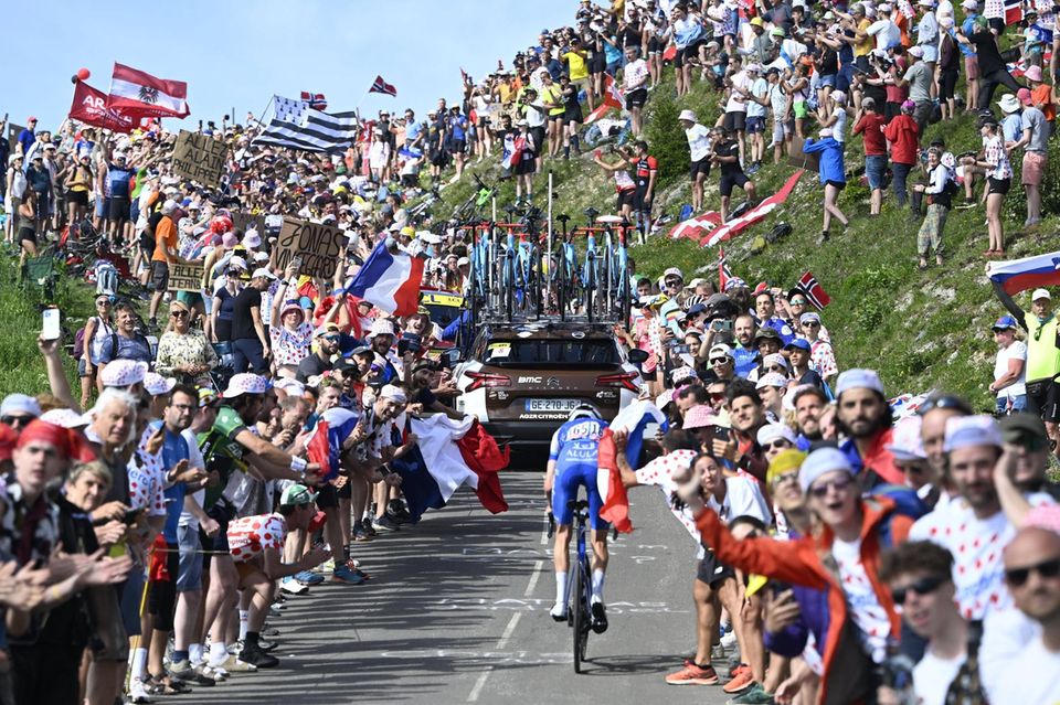 Radfahrer fährt durch Menschenmenge den Berg hoch