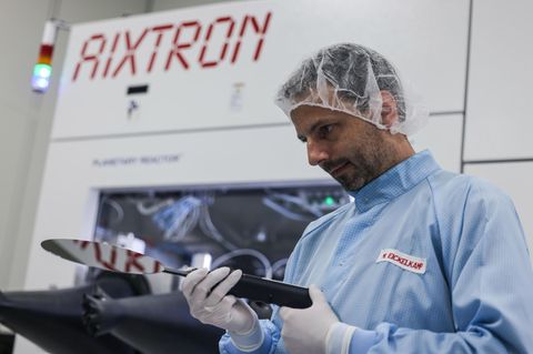 Ein Mitarbeiter von Aixtron betrachtet einen Halbleiter-Rohling