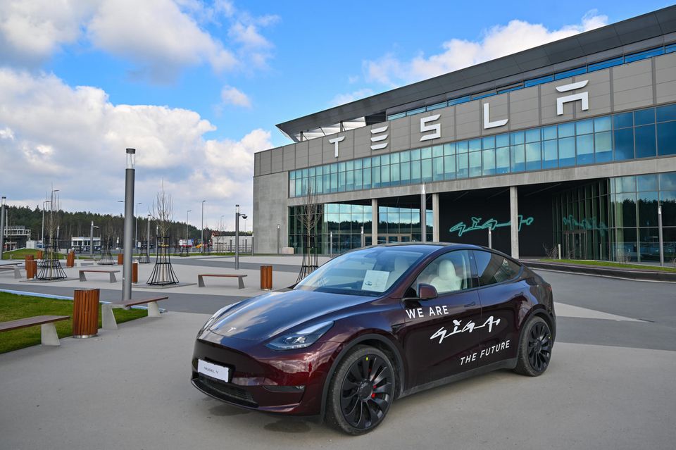 Ein Tesla steht vor dem Eingang zur Fabrik des E-Autoherstellers in Grünheide