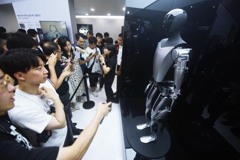 Einer der bekanntesten KI-Roboter ist Teslas „Optimus“, der hier von Besuchern einer KI-Konferenz in Schanghai bestaunt wird