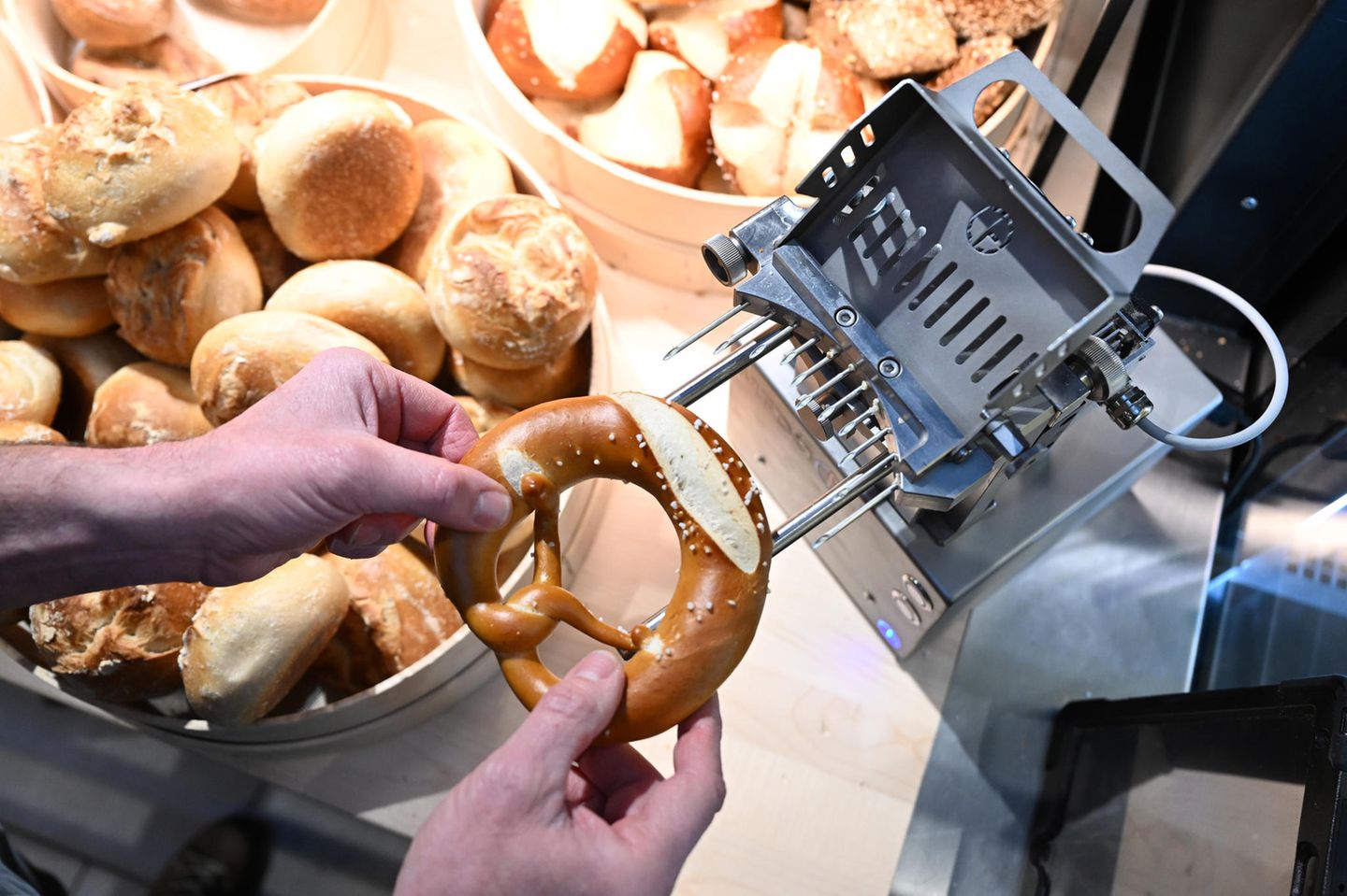 Eine Brezel wird mit einer neu erfundenen Maschine mit Butter befüllt