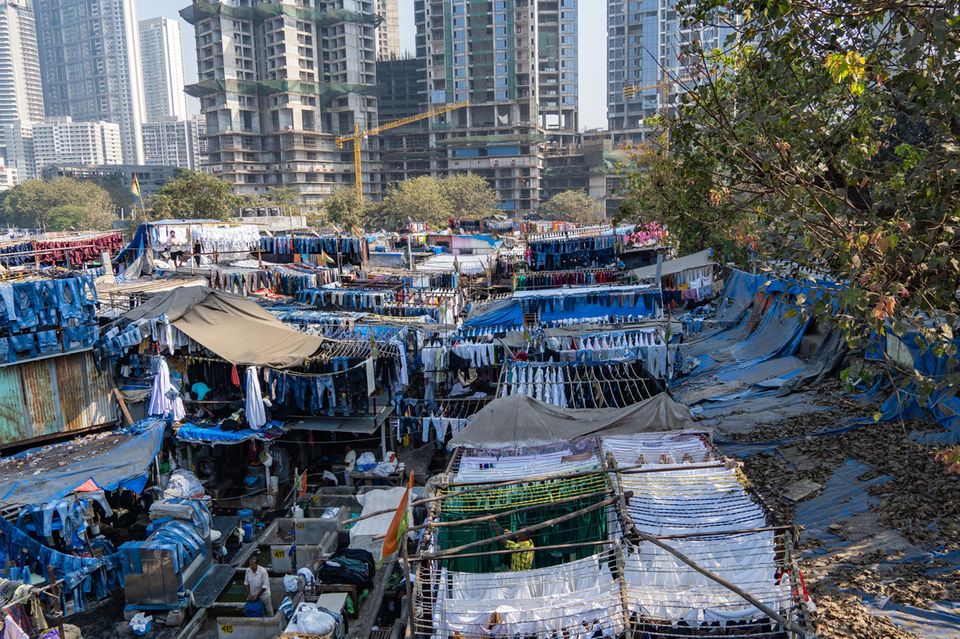 Eine entscheidende Entwicklung in der Bewertung von Narendra Modis Bilanz der wirtschaftlichen Entwicklung ist die Zahl der Menschen, die den Weg aus der Armut gefunden haben. Am treffsichersten misst das der National Multidimensional Poverty Index (MPI), der neben Einkommensarmut eine Reihe weiterer Entbehrungen von Ernährung über Bildung bis sanitäre Bedingungen und Unterkunft einbezieht. Lebten 2005 nach diesem Maßstab noch mehr als 50 Prozent aller Inder in Armut, so waren es ein Jahrzehnt später noch 25 Prozent – und nach der letzten Haushaltsbefragung (2021) 15 Prozent. Das Los der Inder, die in Armut leben, hat sich dank Wirtschaftswachstum und Programmen der sozialen Unterstützung kontinuierlich verbessert. Im Bild: die größte Wäscherei unter freiem Himmel, Dhobi Ghat im Slum der Wirtschaftsmetropole Mumbai.