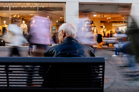 Ein ältere Mann sitzt auf einer Bank