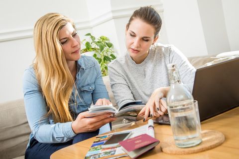 Zwei Frauen planen ihre Reise am Laptop