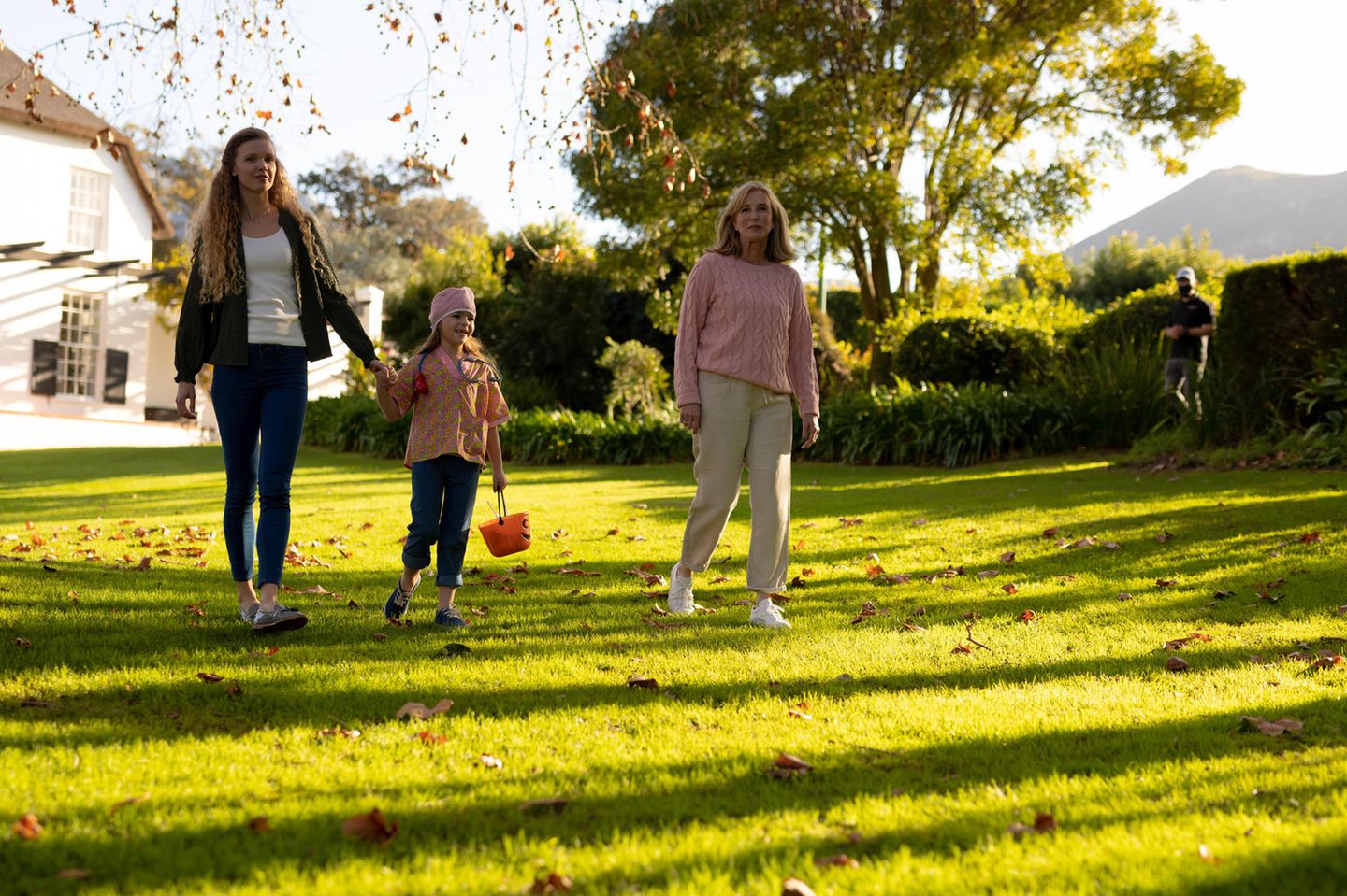 Drei Generationen spazieren im herbstlichen Garten