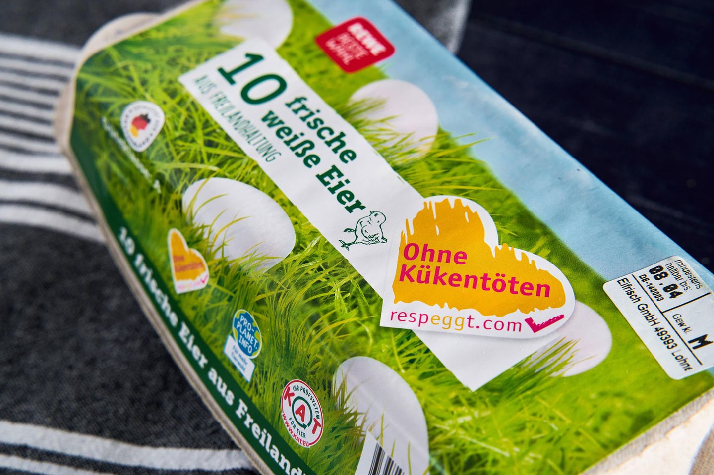 Eine Packung weiße Eier aus Freilandhaltung von Rewe mit der Aufschrift ohne Kükentöten