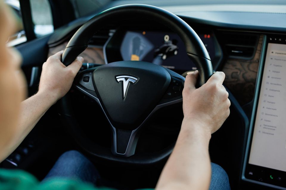Ein Mann sitzt am Steuer eines Tesla