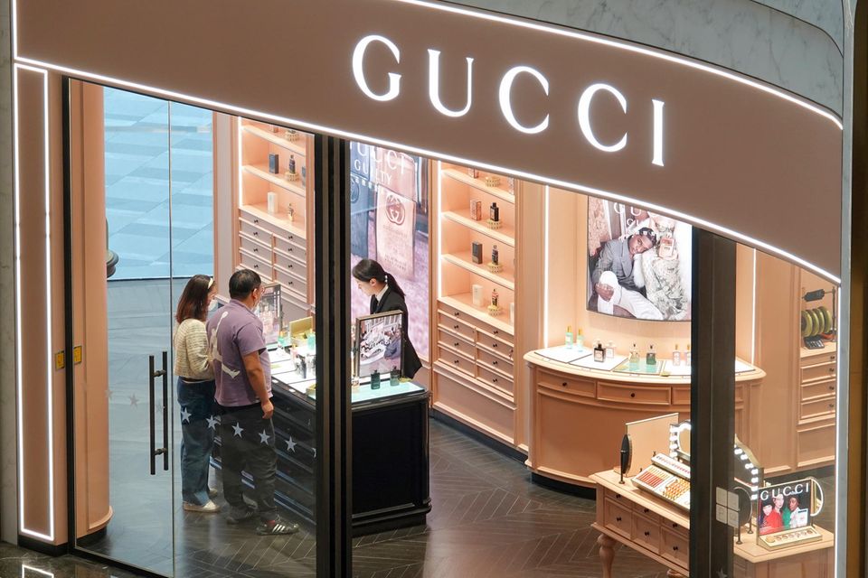 In einem Gucci-Geschäft in China berät eine Verkäuferin zwei Kunden