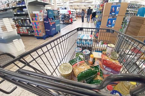 Ein Einkaufswagen mit Lebensmitteln steht in einem Supermarkt