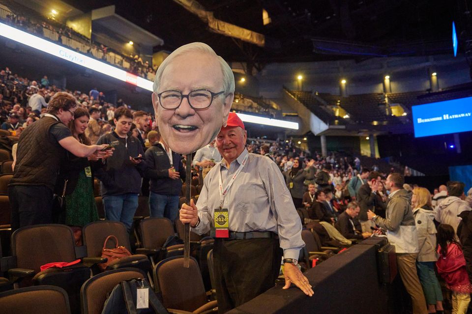 Ein Teilnehmer der Aktionärsversammlung hält einen Papp-Ausschnitt mit Warren Buffett