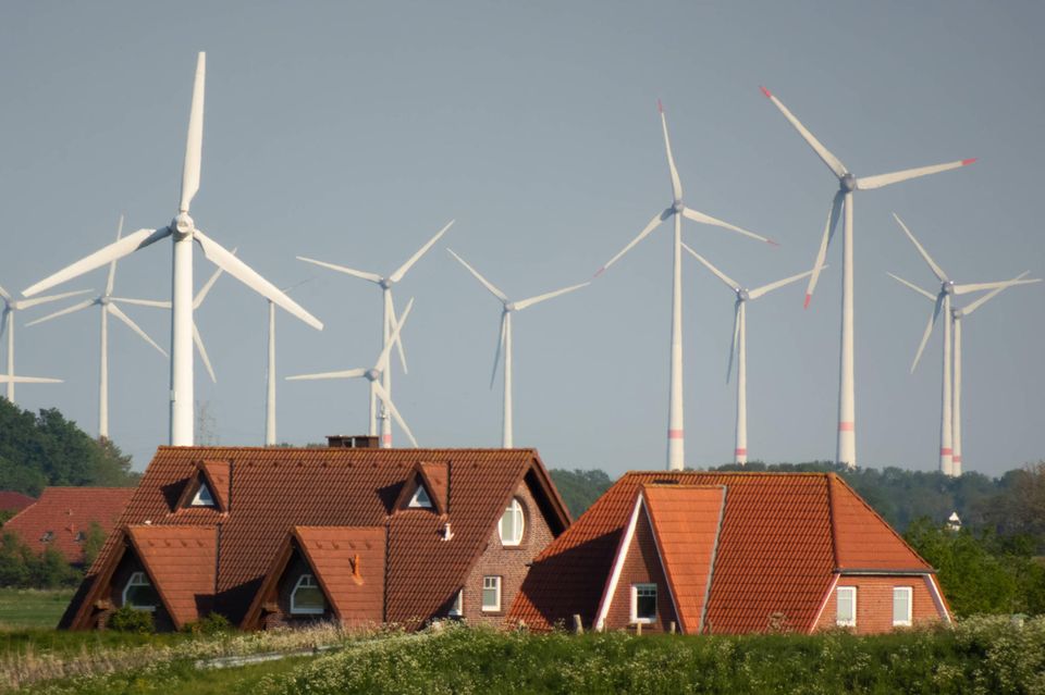 Wohnhäuser und Windräder hinter dem Deich bei Nessmersiel in Ostfriesland