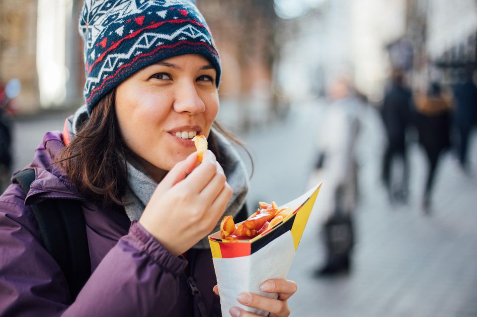 Eine Frau isst Pommes frites