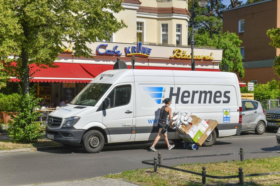 Ein Mann schiebt Pakete auf einem Wagen