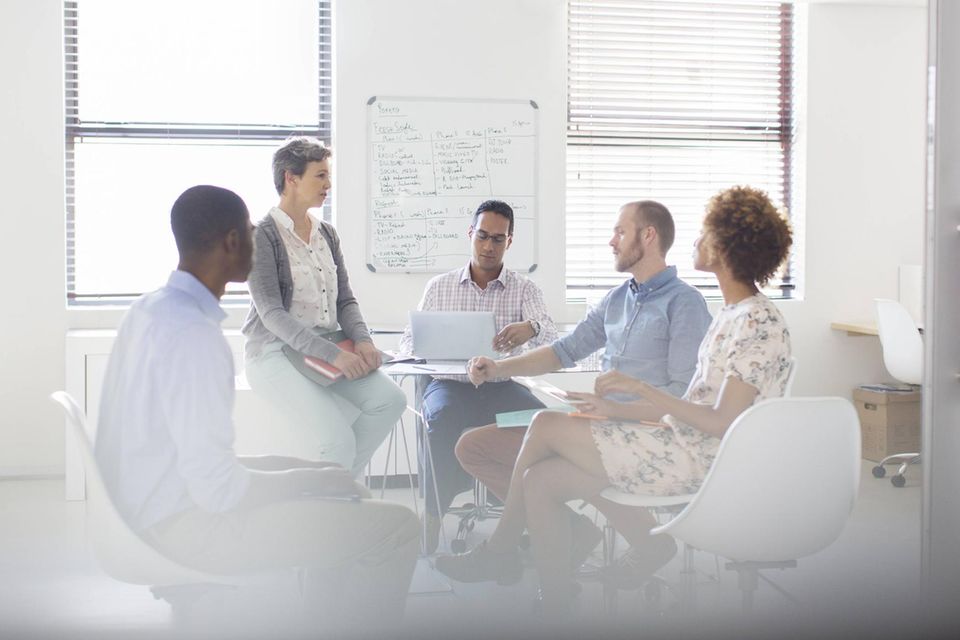 Zwei Frauen und drei Männer bei einem Meeting im Büro