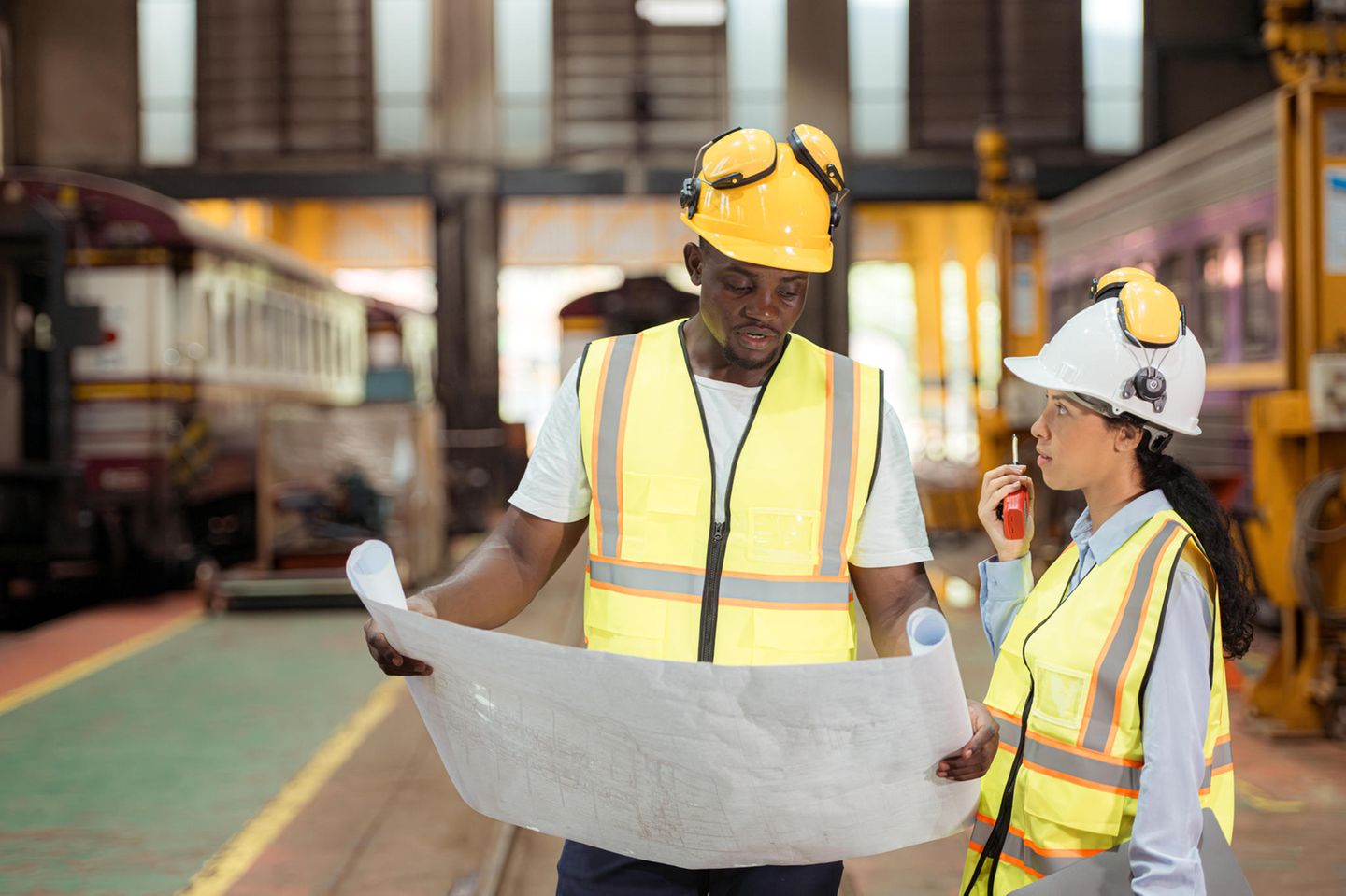 Eine Ingenieurin und ein Ingenieur auf einer Bahnanlage