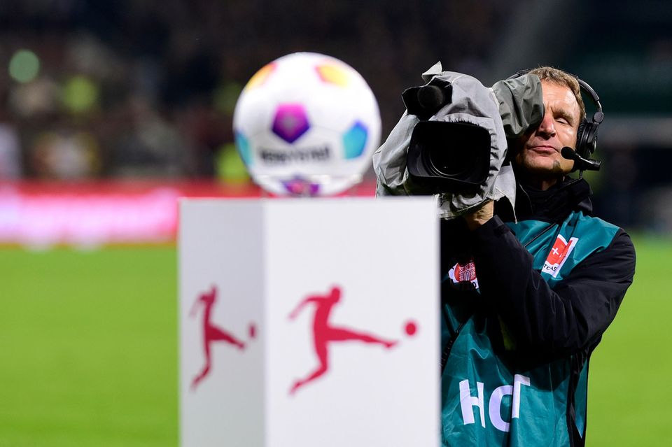 Ein Kameramann filmt einen Fußball