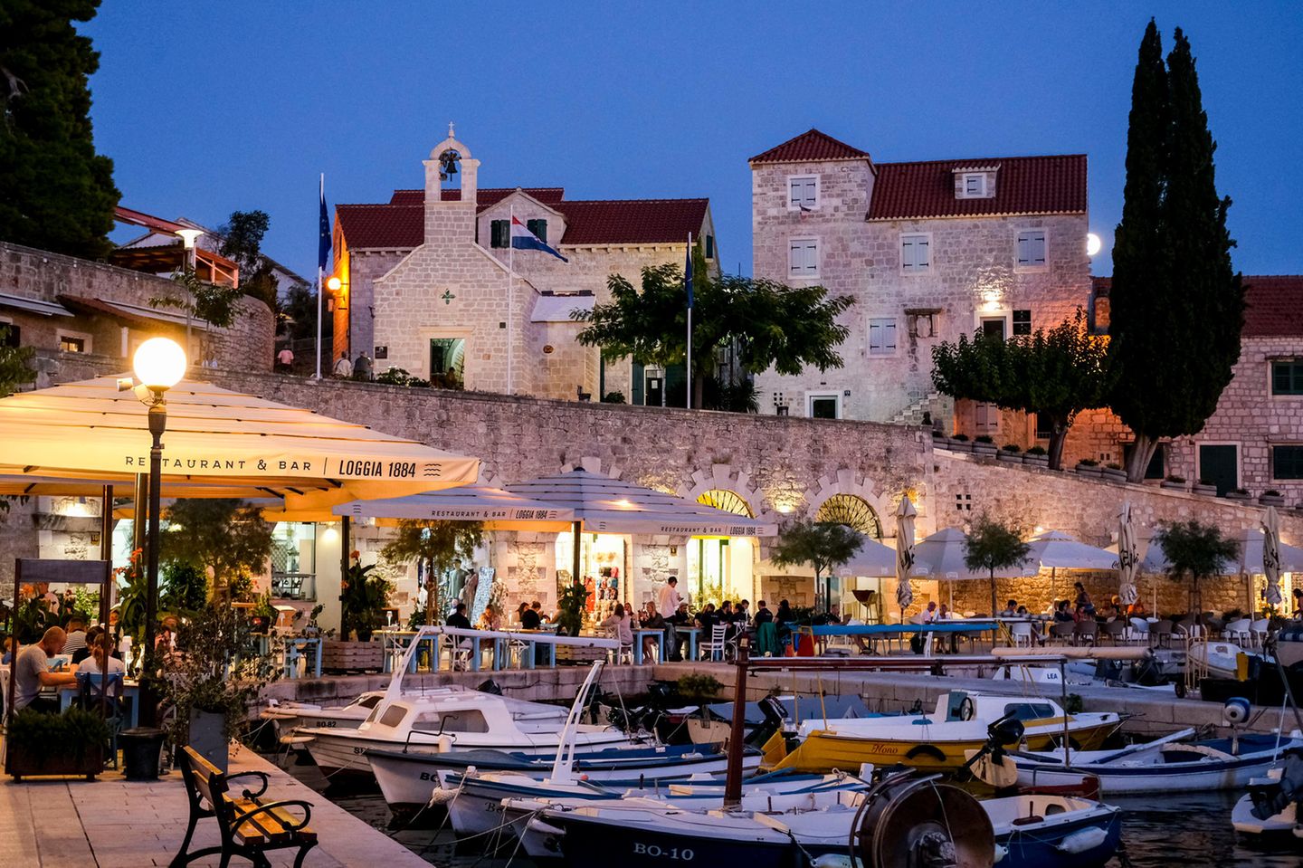 Der Hafen mit Booten, Cafés und Restaurants in Bol auf der Insel Brac am Abend