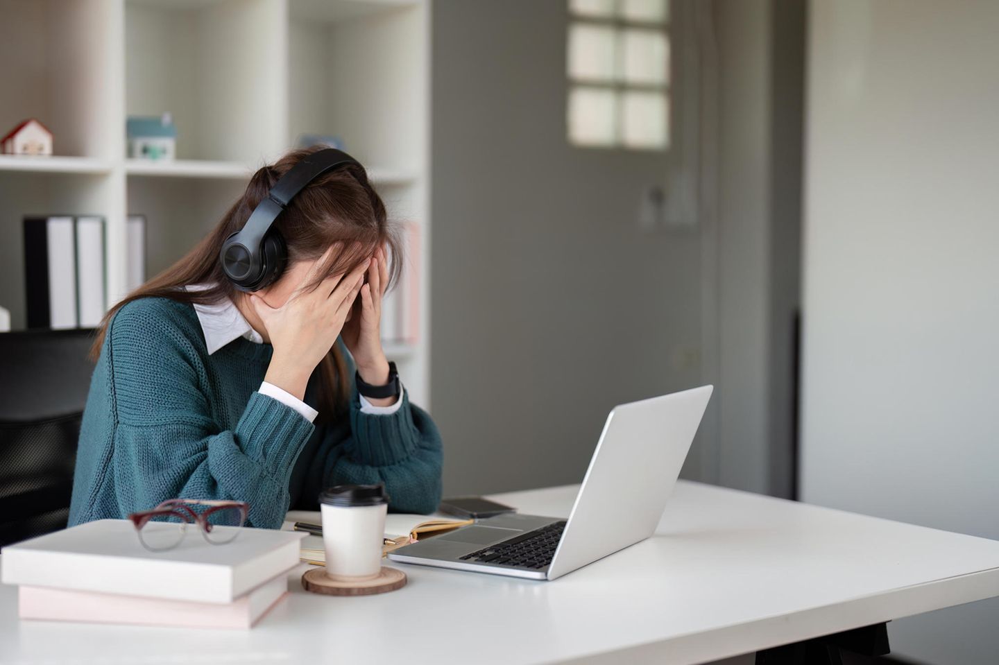 Burnout: Verzweifelte Frau am Arbeitsplatz