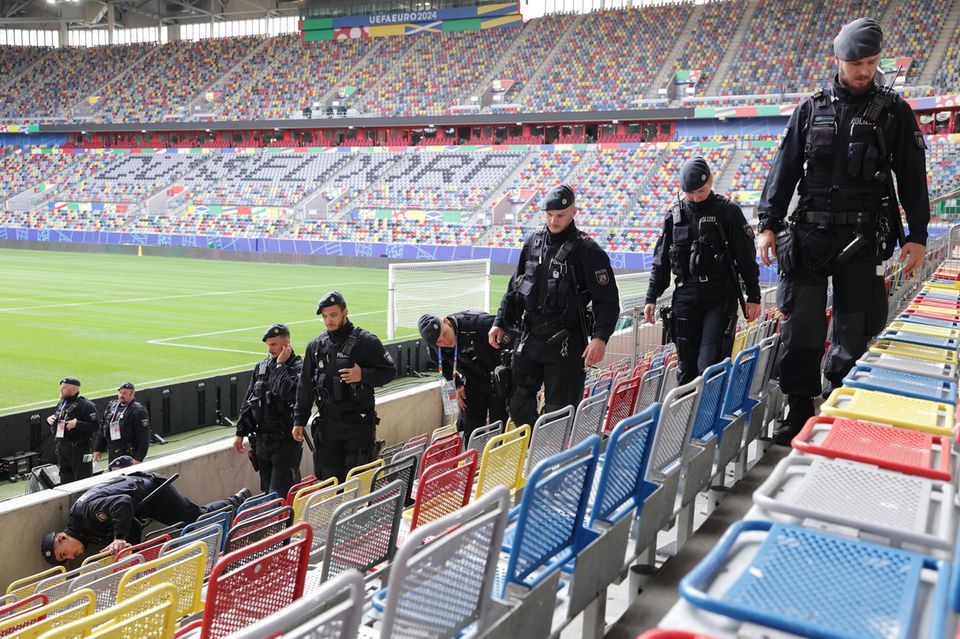 Polizisten schreiten in Düsseldorf die Sitzreihen des Stadions vor der Fußball-EM 2024 ab