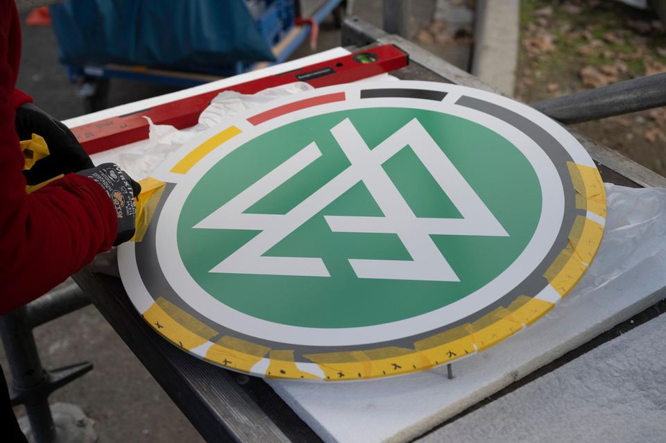 Zwei Arbeiter montieren das DFB-Logo am DFB-Campus in Frankfurt