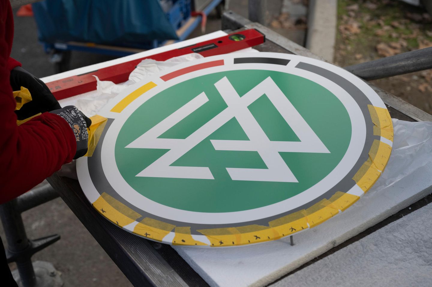 Zwei Arbeiter montieren das DFB-Logo am DFB-Campus in Frankfurt