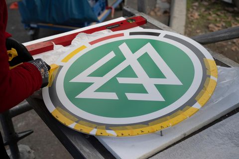 Zwei Arbeiter montieren das DFB-Logo am DFB-Campus in Frankfurt